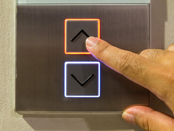 View of a hand selecting an elevator keypad